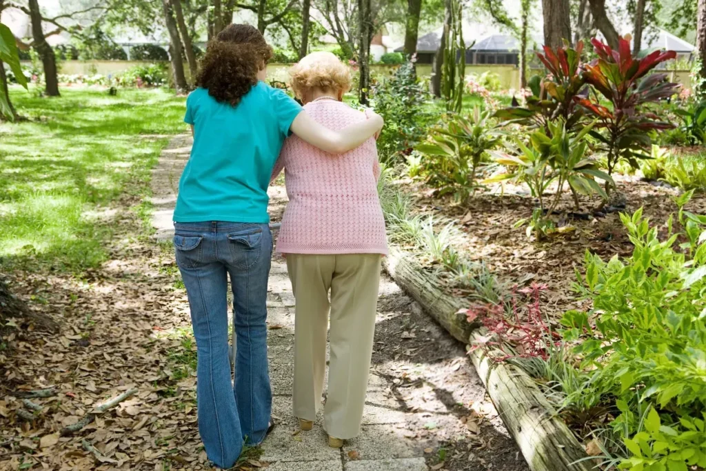 Cuidadora de personas mayores acompañando a anciana en el campo en Madrid