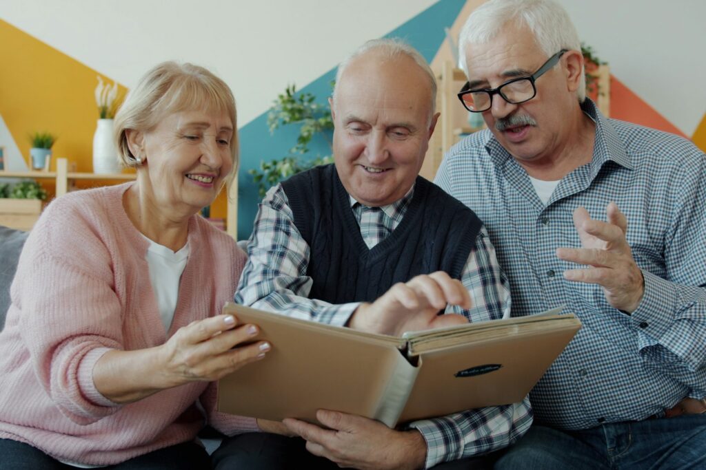Personas mayores mirando un álbum de fotos para estimular la memoria