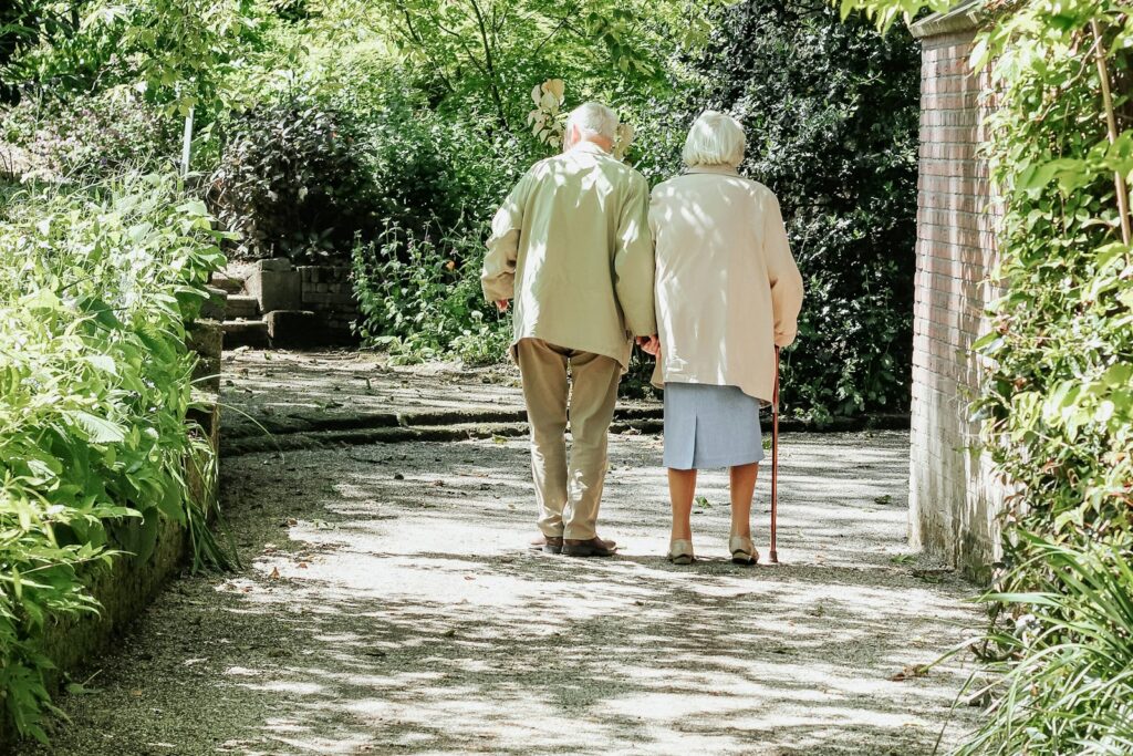 Pareja de personas mayores paseando por un parque
