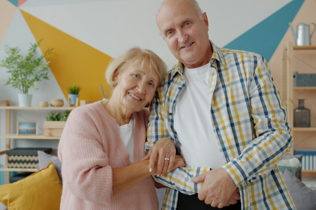 Pareja de personas mayores sonriendo en su casa