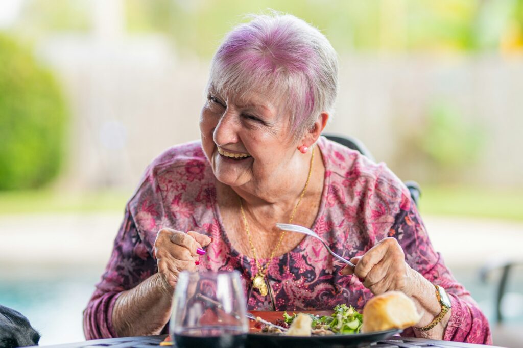 Señora mayor comiendo con buen ánimo en casa